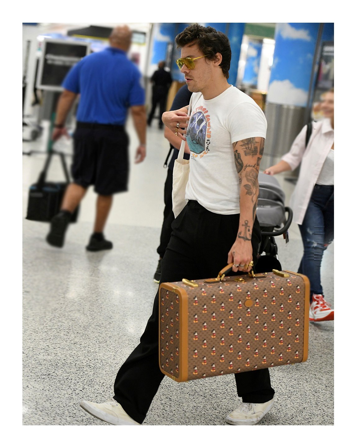 Harry Styles—who stars in the Gucci Mémoire d’une Odeur campaign seen on Gucci Beauty—spotted in Miami with a Gucci Cruise 2020 mini Disney X Gucci GG suitcase with all-over Mickey Mouse print, Gucci Eyewear acetate sunglasses and Gucci Jewelry rings.