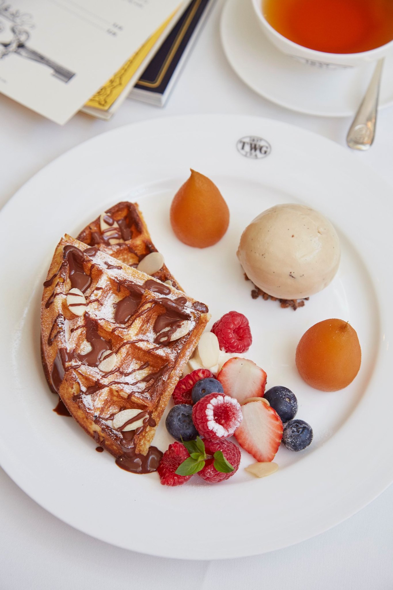 Waffles accompanied by poached pears infused with Red Christmas Tea served with chocolate sauce, almond slices and a scoop of Vanilla Bourbon Tea ice cream. 