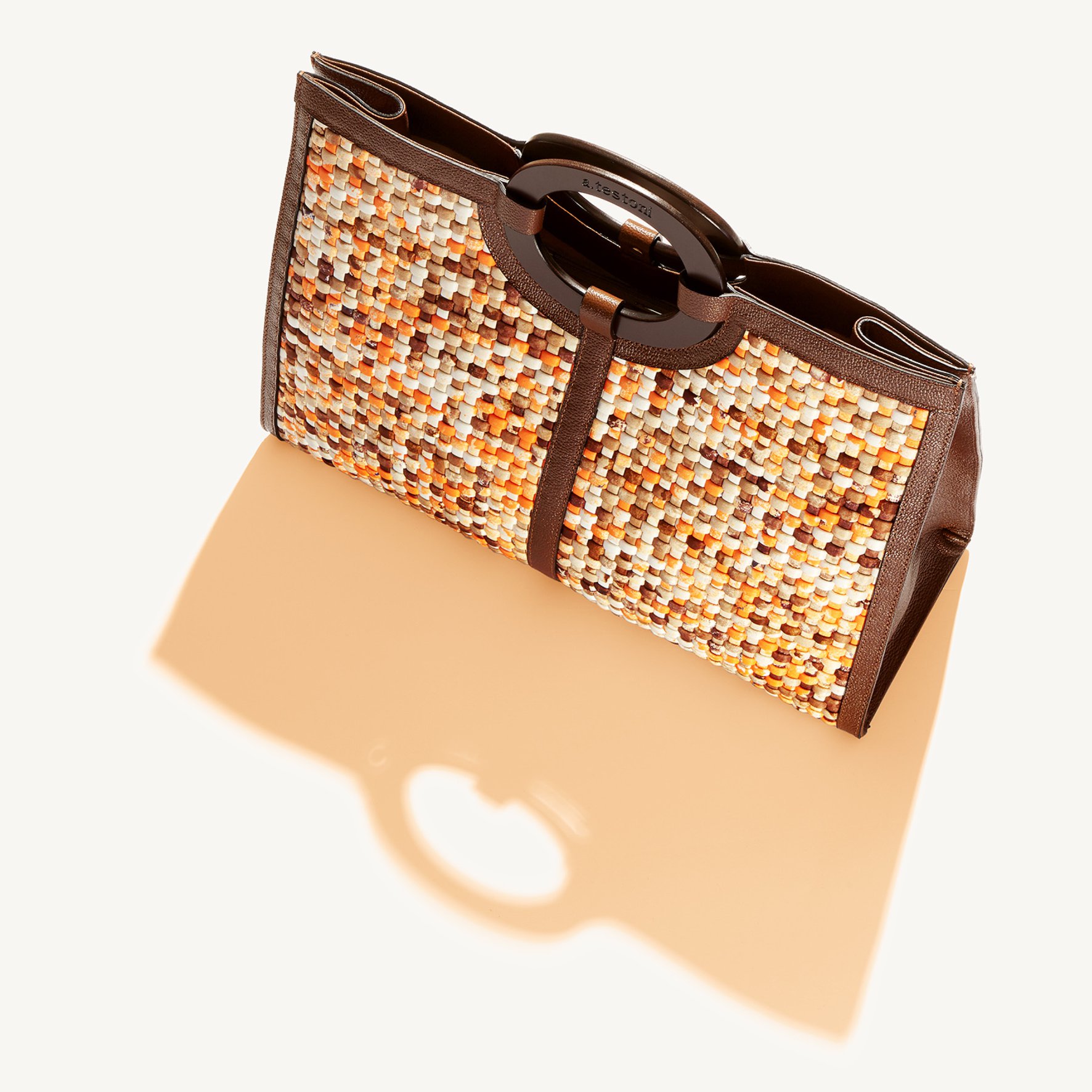 Sand and neon woven detailing decorate the Selena bag: a spring must-have.