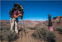 Same experience, different perspectives: Kevin Fedarko rests on his poles, while Kelly McGrath stands on her head, subsequent to a five-hour climb to the rim of the Grand Canyon after hiking its 750-mile length.