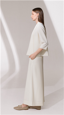 豐富紋理的布料加上 A line 的剪裁和配襯效果，米白色的套裝簡約卻見精緻。